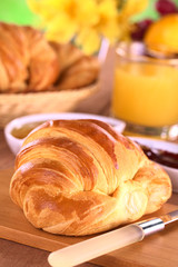 Croissant, jam, fruits and orange juice for breakfast