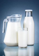 Full Jug, Bottle of fresh milk and glass isolated on dark grey b