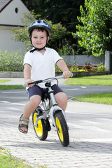 Baby boy on traffic playground for childs with crash helmet