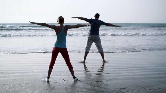 Couple exercising on the beach