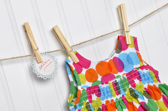 Polka Dot Baby Dress on a Clothesline with Handwritten Sale Sign