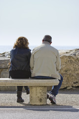 Marito e moglie su una panchina in riva al mare
