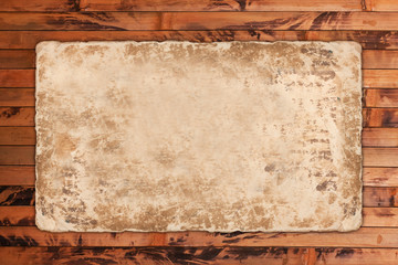 Old faded paper sheet on a wooden background