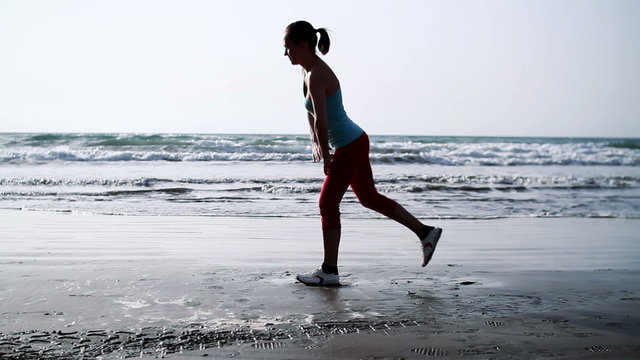 Young woman exercising on the beach