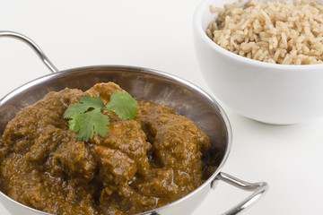 Goan Chicken Chacuti served & pilau rice on a white background