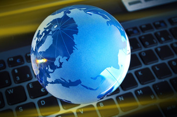 Blau beleuchteter Glasglobus auf Tastatur