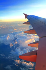 Fototapeta na wymiar Widok na skrzydło samolotu odrzutowego z wzorców cloud