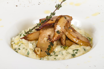 photo of delicious risotto dish with herbs and mushrooms on whit