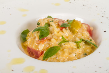 photo of delicious risotto dish with herbs and tomato on white b