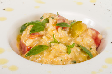 photo of delicious risotto dish with herbs and tomato on white b