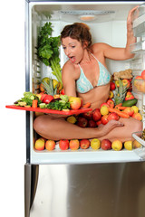 Woman sitting in a fridge