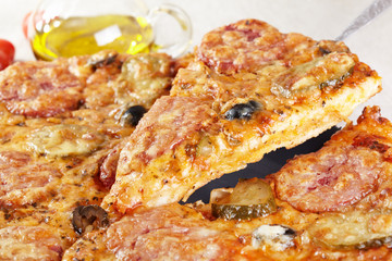 Italian cuisine. Pizza with salami, pickles and olives