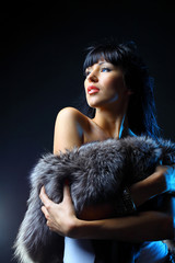 Beautiful woman covering the fur. Fashion art photo