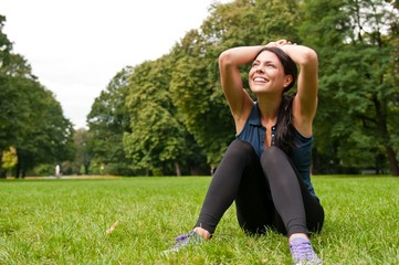 Relax - sportswoman sitting in grass