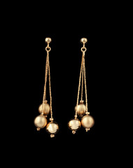 gold earrings over black background