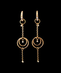 Fototapeta na wymiar gold earrings over black background