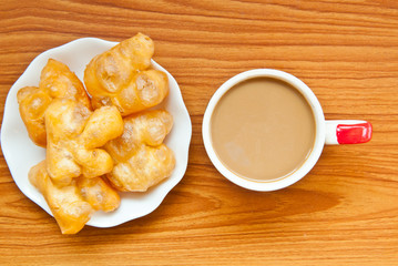 fried dough and coffee on wood background