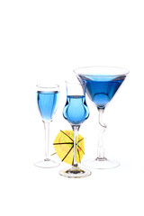 Three wineglasses are filled with beverage and cocktail umbrella
