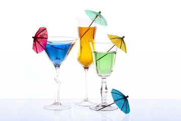 Wineglasses are filled with beverages and cocktail umbrellas