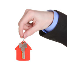 Key with house-shaped charm in hand isolated on white