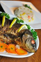 Carp baked with vegetables (carrot, onion, lemon, spice)