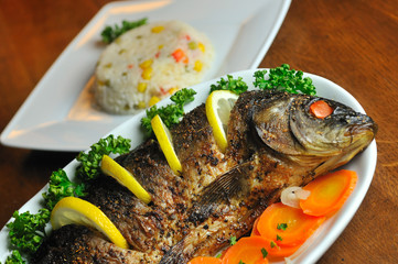 Carp baked with vegetables (carrot, onion, lemon, spice)