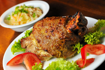 pork meat fried on grill with tomato and lettuce