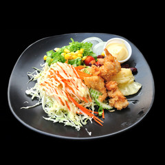 Fried chicken with salad isolated on black background
