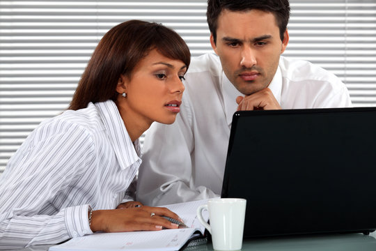 Business couple sitting at a laptop