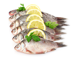 Fresh fishes with lemon and parsley isolated on white