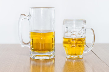 Two Different Beer Mugs Half Full with Lager