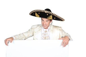 Man in a mariachi costume with  board for message