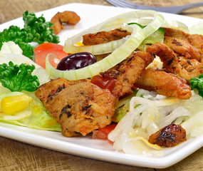 A meal of grilled meat and mixed salad on a plate