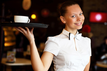 Portrait of young waitress holding a tray