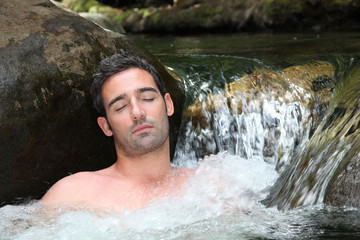 Fototapeta premium Closeup of man relaxing in natural river spa