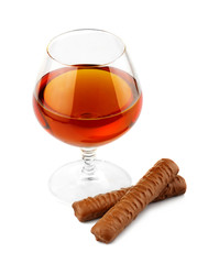 Glass with cognac and chocolate isolated on white