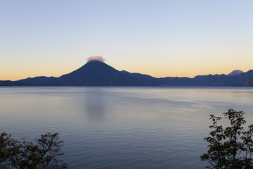 Vue zen sur lac et volcan nuageux