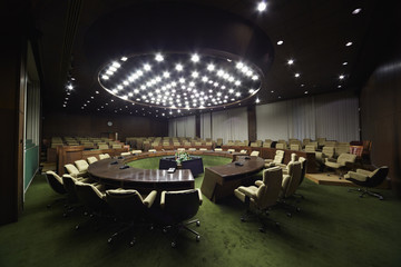 Fototapeta premium Auditorium with round oak table and beige armchairs