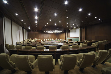 Boardroom with round oak table and beige armchairs around it