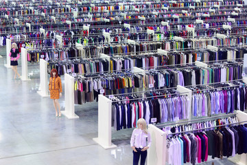 Big clothing store, dummies and many rows with hangers