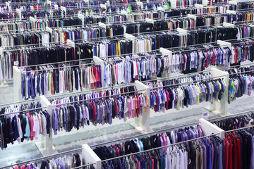 Big clothing store, many rows with hangers with skirts