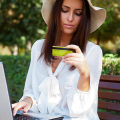 Young elegant woman wearing straw hat and white dress
