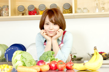 Beautiful young woman in kitchen making salad