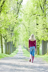 Fototapeta na wymiar kobieta nosi buty gumowe wiosną alejce