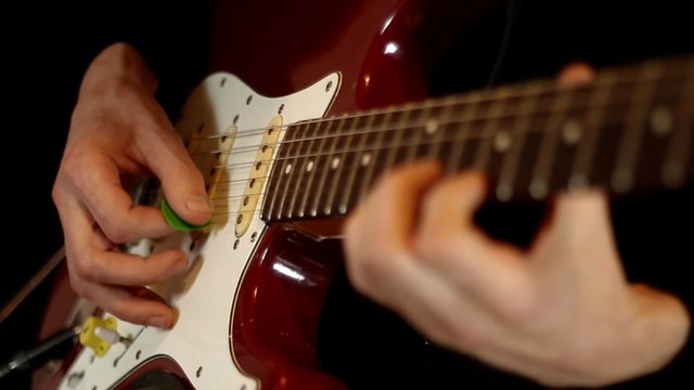 Male hands play on electric guitar