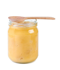 Glass jar with honey and wooden spoon.