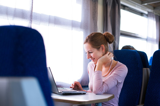 Young Woman Using Her Laptop Computer While On The Train