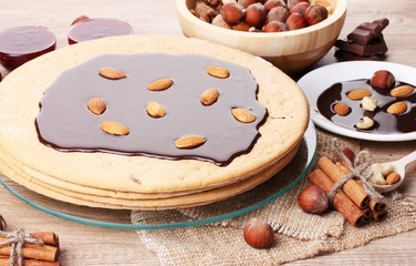 cake on glass stand and nuts on wooden  table