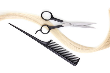 Shiny blond hair with hair cutting shears and comb isolated