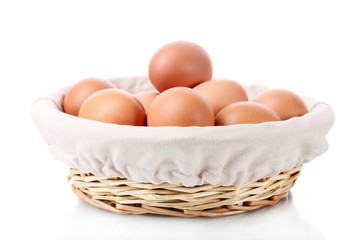 brown eggs in basket isolated on white